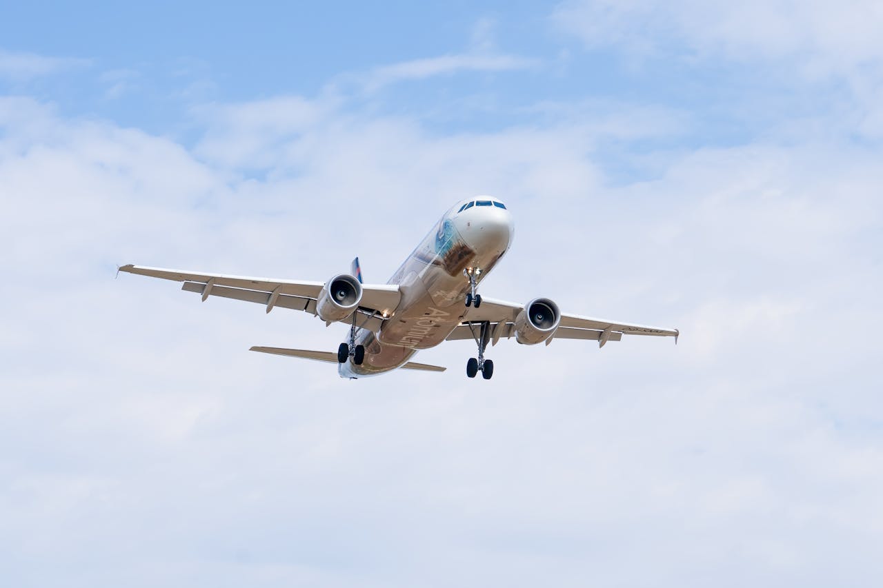 An airliner captured in flight with a clear blue sky, showcasing commercial aviation above Manises, Spain.