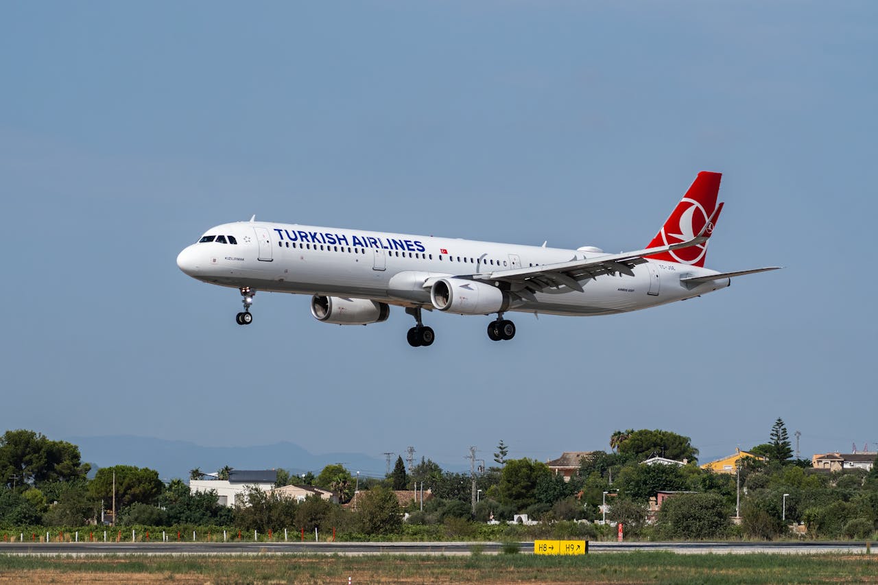 Turkish Airlines Airbus A321 landing at Manises Airport, Valencia, Spain under clear skies.